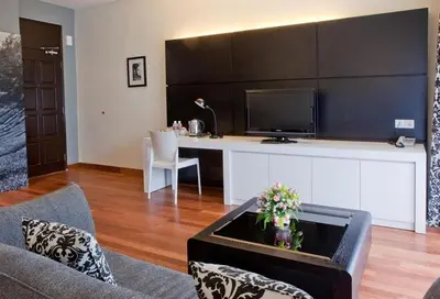 a living room with a couch and a desk with a tv at Strawberry Park Resort in Cameron Highlands