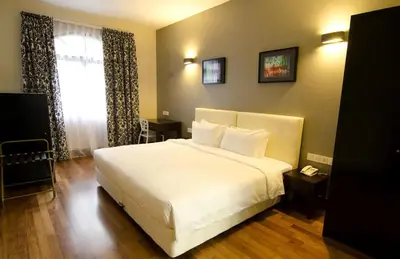 a bedroom with a large white bed and a window at Strawberry Park Resort in Cameron Highlands
