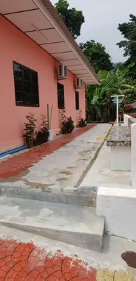 a pink house with a sidewalk in front of it at Teratak Nipah Homestay Teluk Nipah Pangkor in Pangkor