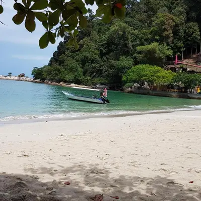 a man is in a boat on the beach at Teratak Nipah Homestay Teluk Nipah Pangkor in Pangkor