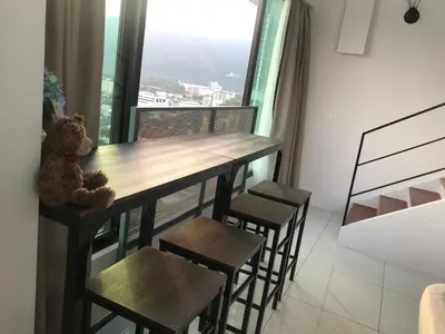 a teddy bear sitting at a table in a room with a window at SUNRISE Gurney Seaview Luxury Duplex in George Town