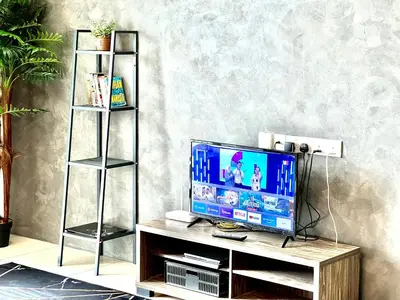 a television on a wooden stand in a living room at 2BR The Yeop Ipoh Homestay Apartment Casa Kayangan Bandar Meru Raya in Ipoh