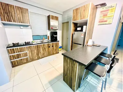 a kitchen with wooden cabinets and a counter top at 2BR The Yeop Ipoh Homestay Apartment Casa Kayangan Bandar Meru Raya in Ipoh