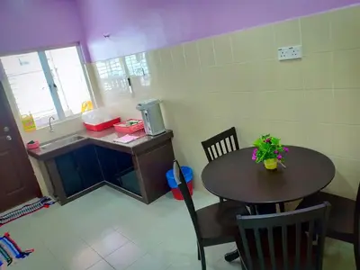 a small kitchen with a table and a sink at Purple TownHouse 9pax 3R2B Wifi in Sekincan