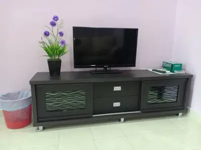 a black entertainment center with a flat screen tv on it at Purple TownHouse 9pax 3R2B Wifi in Sekincan