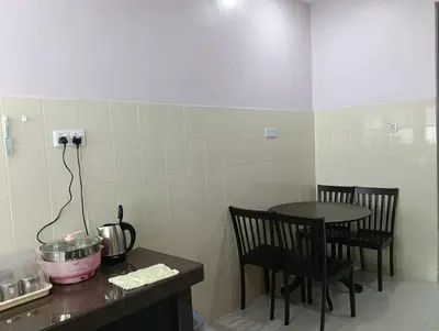 a kitchen with a table and a table and chairs at Purple TownHouse 9pax 3R2B Wifi in Sekincan