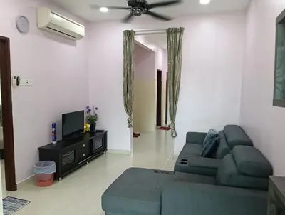 a living room with a couch and a tv at Purple TownHouse 9pax 3R2B Wifi in Sekincan