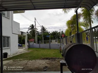 a barrel sitting in a yard next to a fence at Sri Manik Guest House Tanjung Karang in Tanjung Karang
