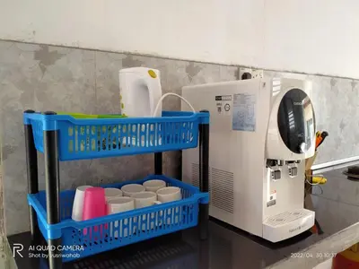 a coffee maker with two blue baskets next to it at Sri Manik Guest House Tanjung Karang in Tanjung Karang
