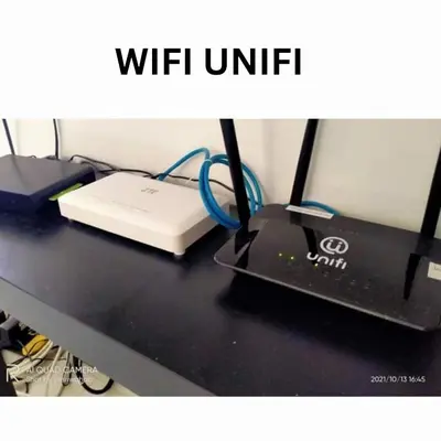 a desk with a laptop and a router on it at Sri Manik Guest House Tanjung Karang in Tanjung Karang