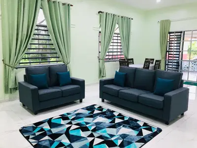 a living room with two couches and a rug at Atocha Homestay - Terong@Taiping in Kampong Salak