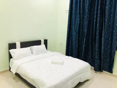 a bedroom with a white bed with a blue curtain at Atocha Homestay - Terong@Taiping in Kampong Salak