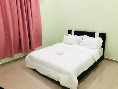 a bedroom with a bed with two glasses on it at Atocha Homestay - Terong@Taiping in Kampong Salak