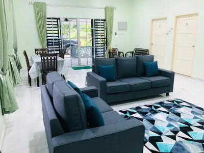 a living room with two couches and a table at Atocha Homestay - Terong@Taiping in Kampong Salak