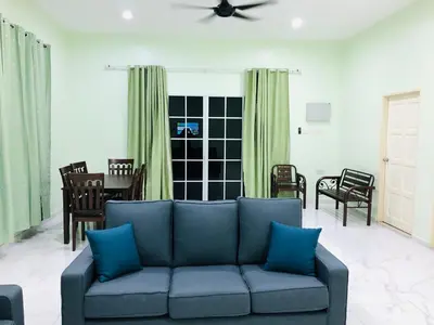 a living room with a blue couch and chairs at Atocha Homestay - Terong@Taiping in Kampong Salak
