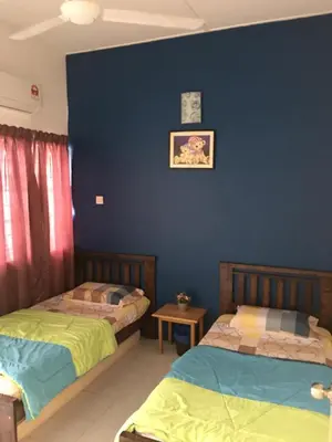 two beds in a room with a blue wall at Ipoh Station 18 in Ipoh