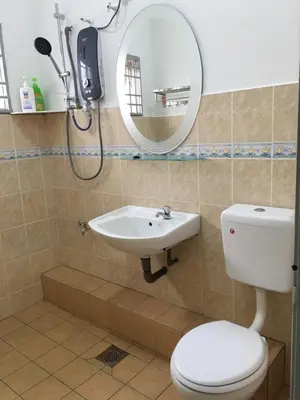a bathroom with a toilet and a sink and a mirror at Ipoh Station 18 in Ipoh