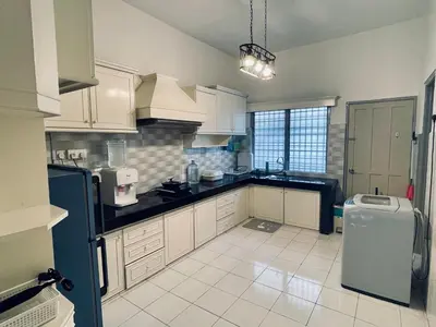 a kitchen with white cabinets and a black counter top at Ipoh Station 18 in Ipoh