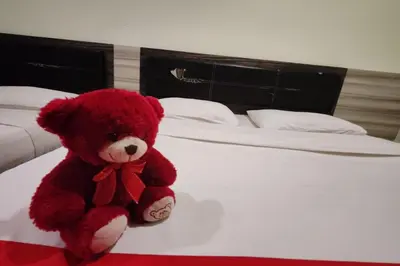 a red teddy bear sitting on a bed at Heaven Mountain Hill 2 Cameron Highlands in Cameron Highlands