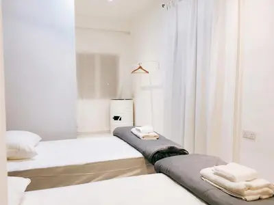 a white room with two beds and a window at 22 Haus in Bukit Mertajam