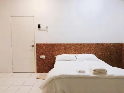 a bedroom with a large bed with white sheets at 22 Haus in Bukit Mertajam