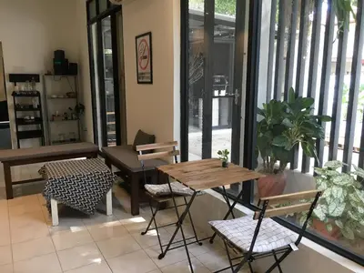 a table and chairs in a room with windows at 22 Haus in Bukit Mertajam
