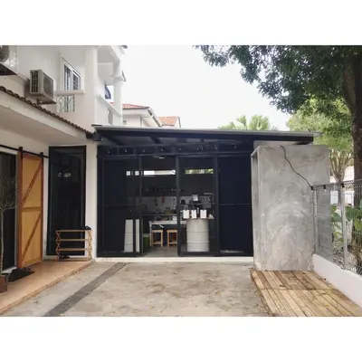 a building with a black garage with a table in it at 22 Haus in Bukit Mertajam