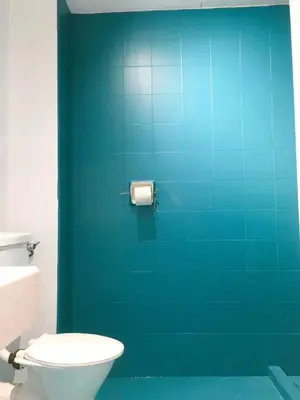 a bathroom with a toilet and a blue wall at 22 Haus in Bukit Mertajam