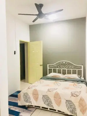 a bedroom with a bed and a ceiling fan at Homestay Cahaya 2 Seri Iskandar in Seri Iskandar