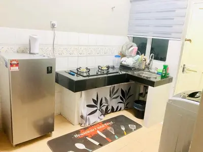 a kitchen with a sink and a refrigerator at Homestay Cahaya 2 Seri Iskandar in Seri Iskandar