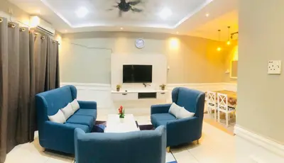 a living room with two blue chairs and a tv at Homestay Cahaya 2 Seri Iskandar in Seri Iskandar