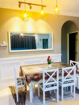 a dining room table with white chairs and a mirror at Homestay Cahaya 2 Seri Iskandar in Seri Iskandar