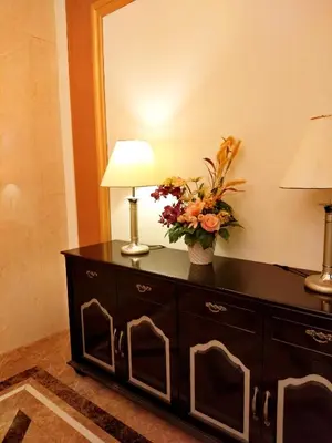a dresser with a lamp and a vase of flowers on it at Kampar Champs Elysees, King Bed Studio unit 12A21 in Kampar