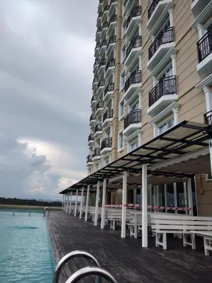 a building with tables and chairs next to the water at Kampar Champs Elysees, King Bed Studio unit 12A21 in Kampar