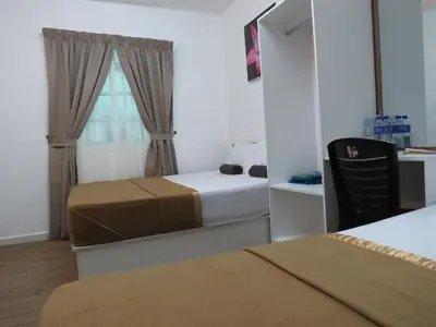 a bedroom with two beds and a window at Darulmakmur Chalet in Cameron Highlands