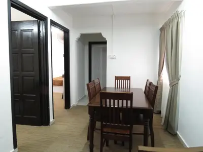 a dining room with a wooden table and chairs at Darulmakmur Chalet in Cameron Highlands