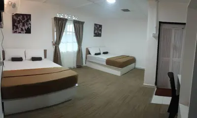 a bedroom with two beds in a room at Darulmakmur Chalet in Cameron Highlands