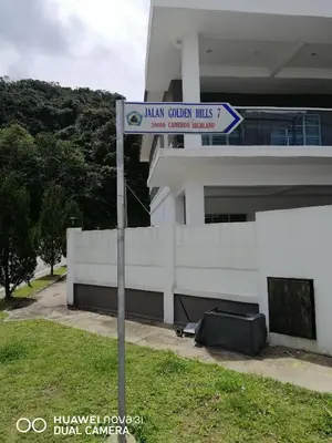 a street sign in front of a building at alyaleesya homestay Teres in Brinchang