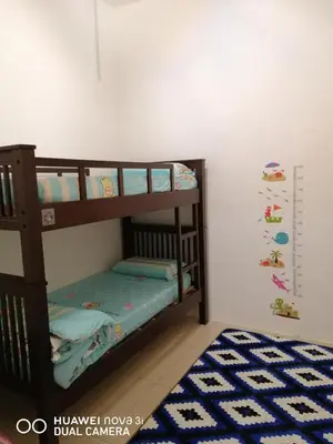 two bunk beds in a room with a blue rug at alyaleesya homestay Teres in Brinchang