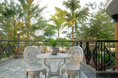 a table and chairs on a balcony with trees at Kinta Bali Villa in Ipoh