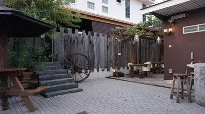 a patio with a wooden fence and a wooden wheel at Kinta Bali Villa in Ipoh