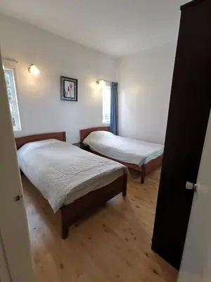 two beds in a room with wooden floors at Little England B8 in Bukit Fraser