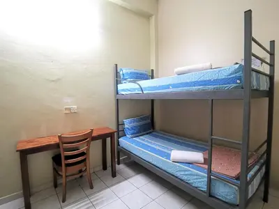 a room with two bunk beds and a wooden table at Star Lodge in George Town