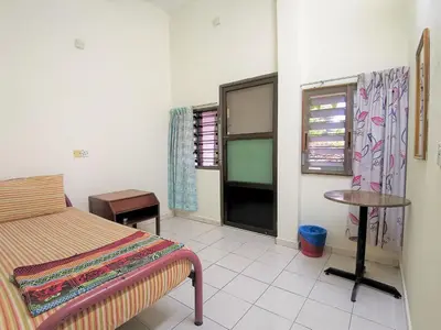 a bedroom with a bed and a table and a window at Star Lodge in George Town