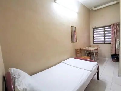 a bedroom with a bed and a table and a window at Star Lodge in George Town