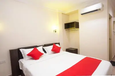 a bedroom with a white bed with red pillows at T P Hotel in Sitiawan