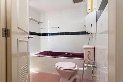 a bathroom with a toilet and a bath tub at T P Hotel in Sitiawan