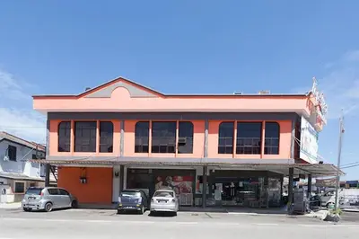 a building with cars parked in front of it at T P Hotel in Sitiawan
