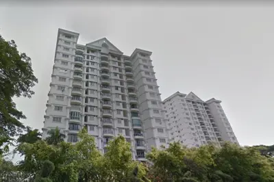 a tall white apartment building with trees in the foreground at RG PRIMA VILLA APARTMENTS in Tanah Rata
