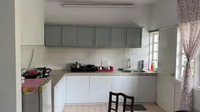 a kitchen with white cabinets and a sink and a chair at Silverpark Resort C2-5-1 or C3-3A-2 walk up in Bukit Fraser